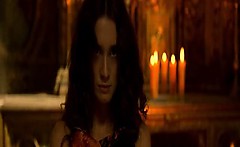 Paz Vega seen from behind in a campfire-lit cave as she